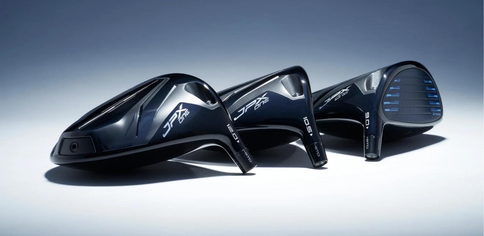 Three Mizuno JPX One Driver heads, lay on a white and blue backdrop